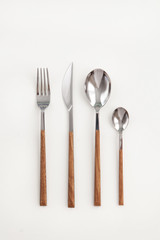 Stainless wooden cutlery view from above on a white background. Top view..Knife and fork for a...