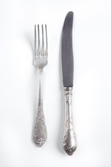 White vintage silver cutlery view from above on a white background. Top view..Antique knife and fork for a festive table for a wedding, birthday or party.