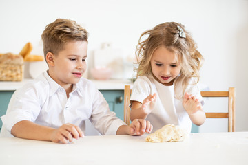 children smiling while preparing the cake dough at home