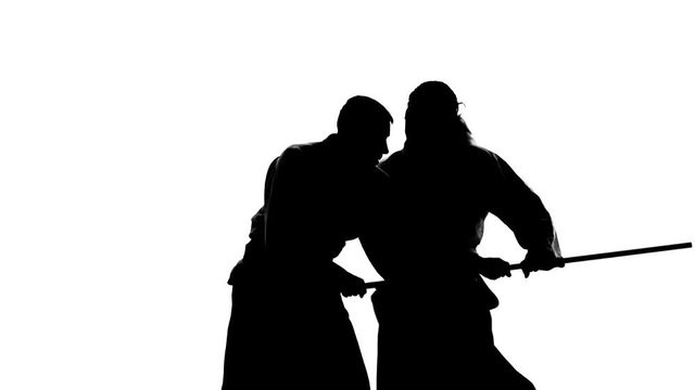 Silhouettes, guys performing aikido using bokken. Isolated, white. Slow motion. Close up.