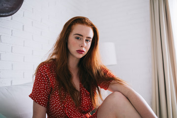 Calm red-haired woman in red polka dot dress