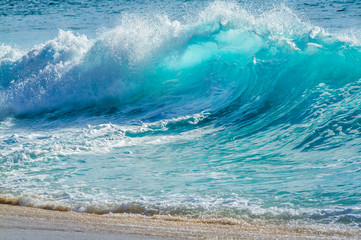 Turquoise colored breaking wave seascape on the beach - 307756219