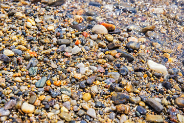 Natural background with stones on the beach of the Mediterranean sea in France on a sunny day