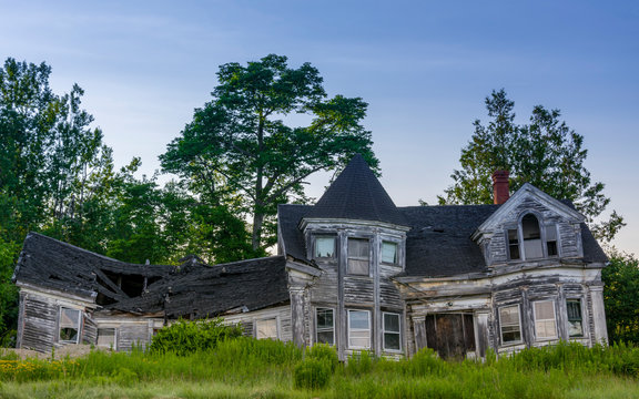 Abandoned House in Rural Maine - What looks to be an once elegant house now abandoned lays in decay and rotting in the countryside.