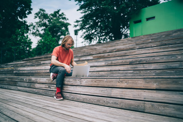 Man watching on laptop in street