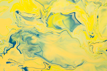 Yellow acrylic liquid paint abstract background