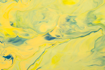 Yellow acrylic liquid paint abstract surface