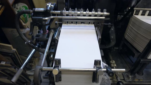 Printed sheets of paper are served in the printing press