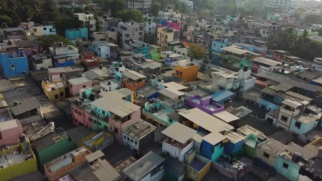 Tilt Up Aerial of Dharavi Slum in Mumbai India, Poor Housing by Dirty Water Canal and Cityscape Skyline