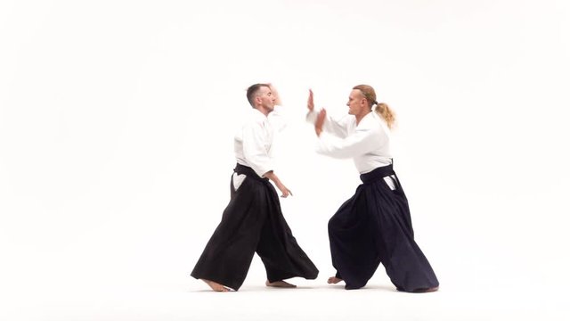 Two guys showing aikido using tanto. Isolated, white. Close up. Slow motion.