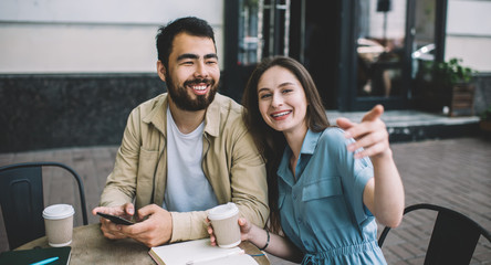 Cheerful multiethnic freelancers laughing at cafe table