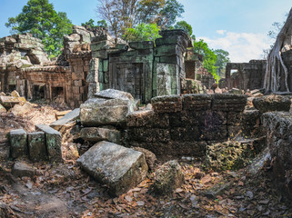 Fototapeta premium Old cobwebble ruins of Preah Khan Temple under blue cloudy sky in Siem Reap, Cambodia.
