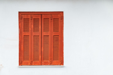 Greek Style windows - wooden vintage window with brown shutters on a white wall. Closed house window, Delphi, Greece
