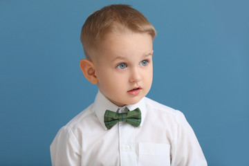 Portrait of stylish little boy on color background