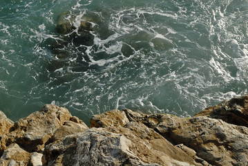 A drop off an edge into the water.