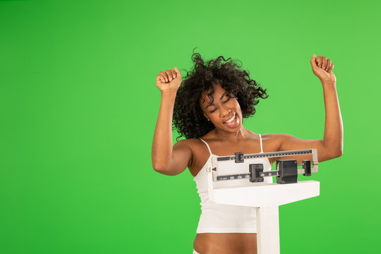 Happy black woman cheering her weight loss on greenscreen