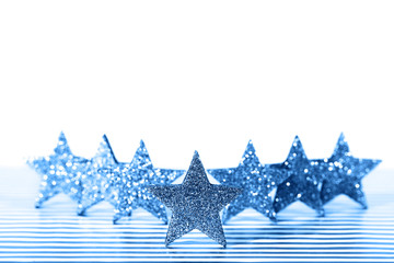 Textured glittering blue stars on white background. Demonstration of color of the year.