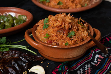 Mexican rice served in traditional clay pot and plate