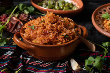 Mexican rice served in traditional clay pot and plate