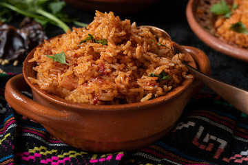 Mexican rice served in traditional clay pot and plate