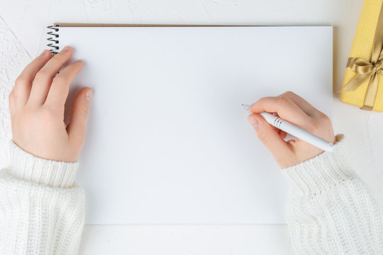 Hands Hold An Blank Notebook Among Gift Box