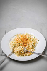 Vegan Spaghetti on white plate; gray napkin on gray countertop