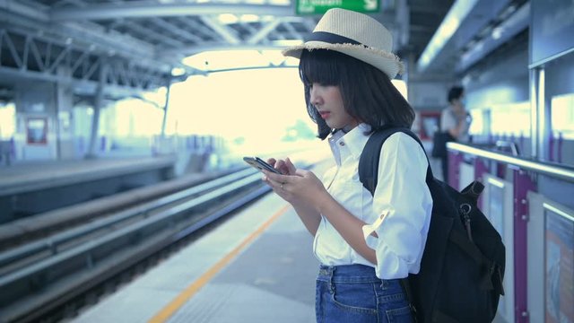 Tourism concept. An Asian woman is waiting for the train at the station. 4k Resolution.