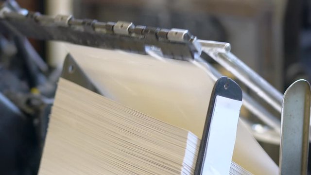 Printed sheets of paper are served in the printing press