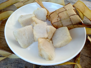 Ketupat or Rice Dumpling On Wooden Background. Ketupat is a natural rice casing made from young coconut leaves for cooking rice during eid Mubarak, Idul Fitri or Aidilfitri