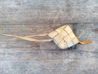 Ketupat or Rice Dumpling On Wooden Background. Ketupat is a natural rice casing made from young coconut leaves for cooking rice during eid Mubarak, Idul Fitri or Aidilfitri