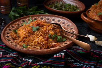 Mexican rice served in traditional clay pot and plate