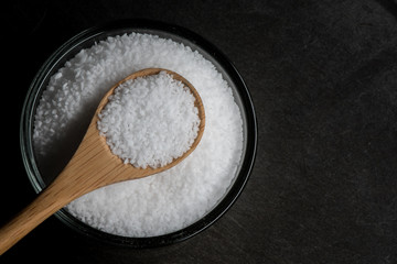 Glass Bowl and Wooden Spoon of Sea Salt with Copy Space to Right
