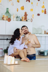 couple in the kitchen with christmas decoration, drink champagne, celebrate christmas