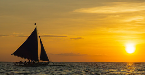 Obraz na płótnie Canvas sailing boat at sunset. orange sky. boat on a sunset background. sailboat on a sunset background. beautiful sunset. unusual sky