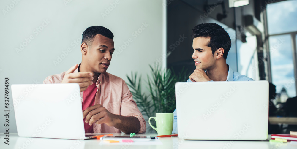 Aufkleber multicultural male colleagues collaborating on information for creating new database for company sit