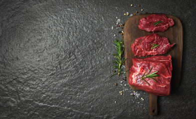 Raw beef steak with herb and spices rosemary / Fresh meat beef sliced on wooden cutting board...