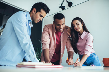 Young colleagues making notes in documents