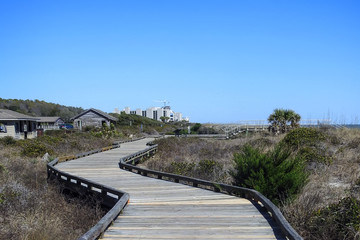 Fototapeta na wymiar Boardwalk winds its way through the dunes to the beach and ocean beyond
