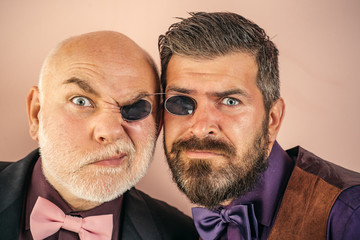 Bearded father and son fooling around in the studio. Glasses. Adult boys in suits and bow ties....