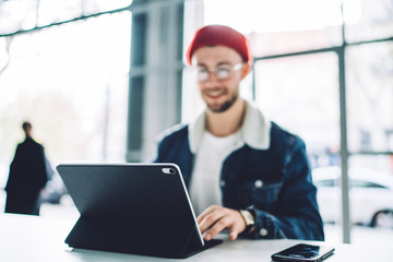 Tablet in black case on table of smiling man