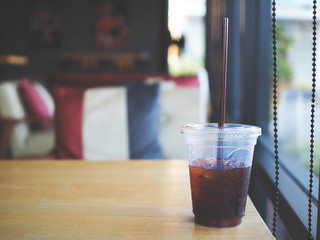 close up of ice black coffee in plastic cup on the table in the cafe