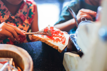 Hand holding bread and Strawberry jam making for breakfast.