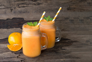 Orange juice fruit smoothies yogurt drink yellow healthy delicious taste in a glass slush for weight loss on wooden background.