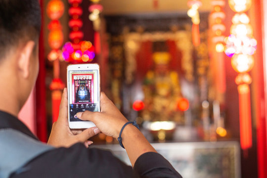 Tourist using mobile phone screen for picture with smartphone of temple in Asia tourism travel. People taking photos during vacation.