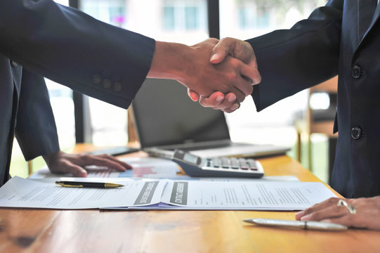Business people shake hands after signing the contract.