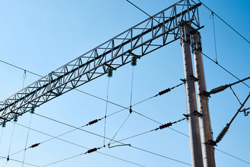 Power electricity wire for trains against blue sky. Close up of the railway electrification system