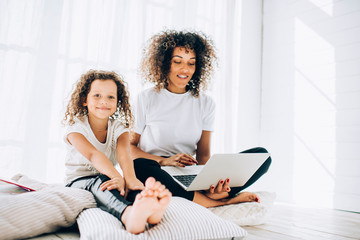 Mother with laptop sitting with daughter