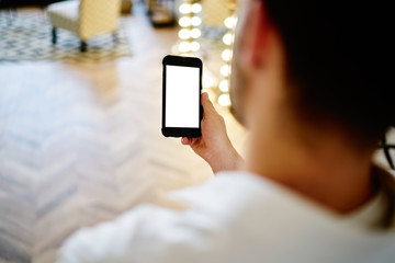 Guy watching cellphone in room in sunny day