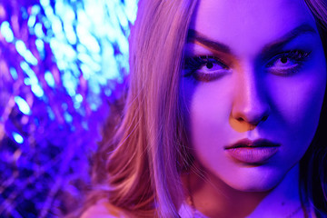 Fototapeta premium Wspaniała blondynka w neonowym kolorze, czerwono-niebieskim kolorze, abstrakcyjne tło. Dziewczyna z białymi soczewkami. Neonowy kolor