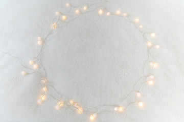 Christmas garland lights from LED bulbs on the carpet background .